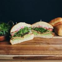 The West Coast Tofurky Sandwich · Oven-roasted tofurky, avocado, mixed greens, tomato, red onion, vegan basil aioli and lemon ...