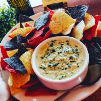 Spinach Artichoke Dip · Creamy spinach and artichoke dip served with tri-color tortilla chips.