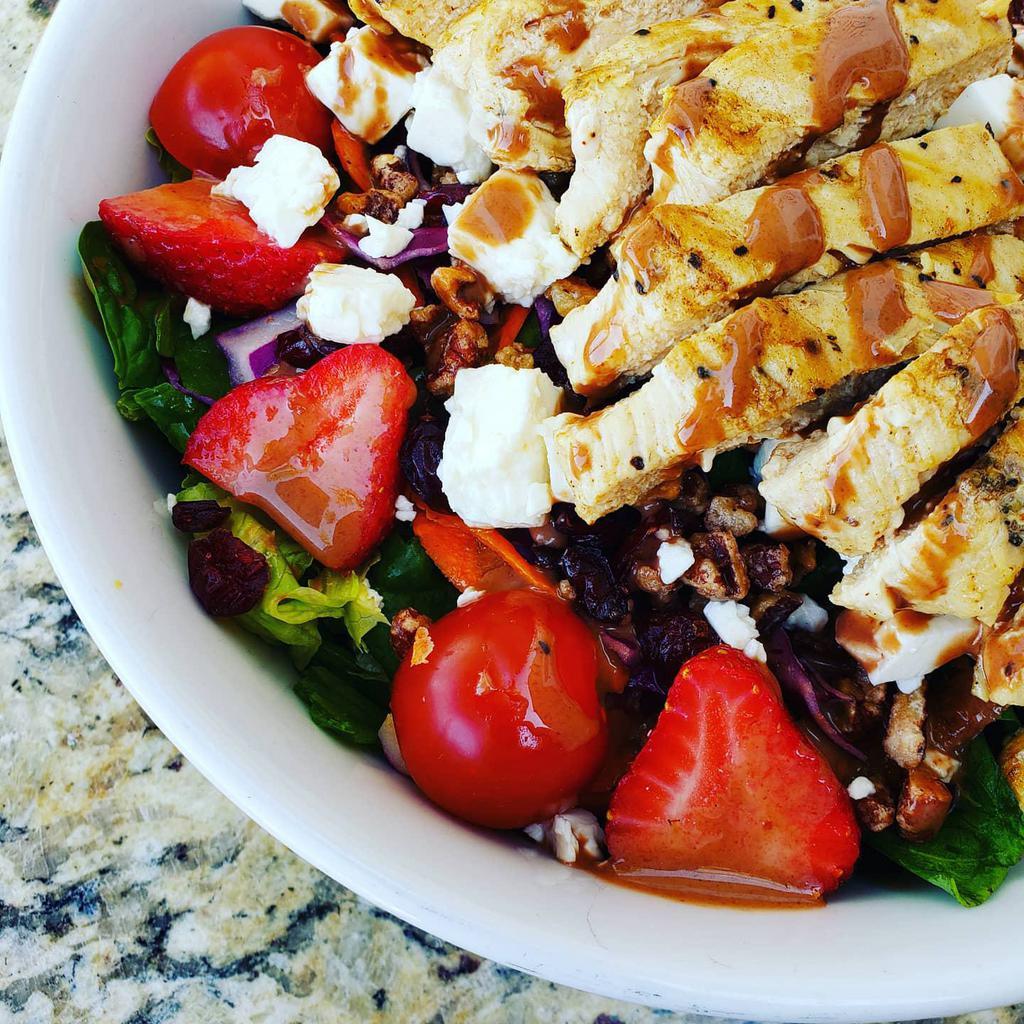 Strawberry Chicken Salad · A fan favorite! Slices of grilled chicken, fresh strawberries, toasted pecans, and crumbled Feta cheese on a bed of mixed greens and spinach. Served with strawberry balsamic dressing.