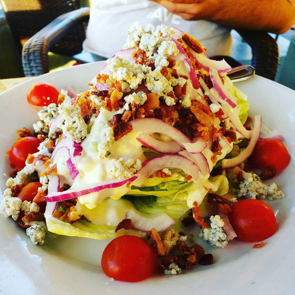Wedge Salad · A cool & crispy wedge of Iceberg topped with crumbled blue cheese, bacon, cherry tomatoes, red onions & blue cheese dressing.