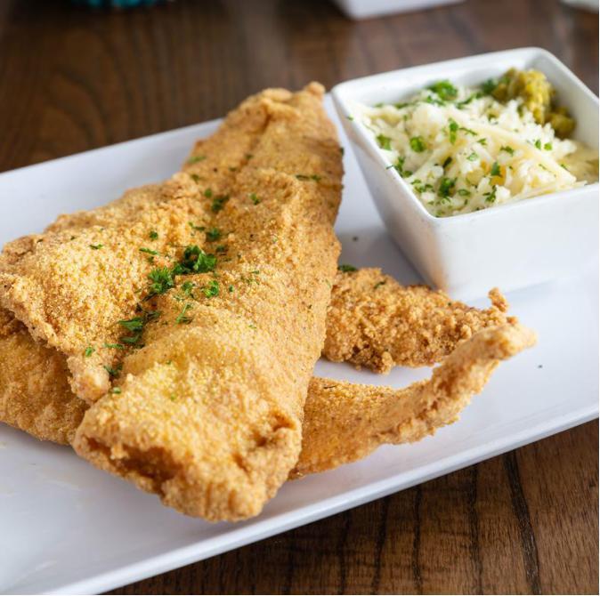 Fish and Grits · White fish fried crispy to perfection with house honey hot sauce and house jalapeno cheese grits.