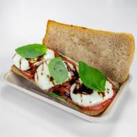 Baked Caprese Sandwich · Whole grain Noble ciabatta, fresh basil, balsamic glaze, tomatoes, and fresh mozzarella. Com...