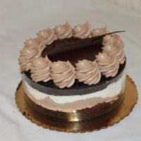 Triple Chocolate Mousse Cake · Two layers of dark chocolate cake filled with fudge, white chocolate mousse and dark chocola...