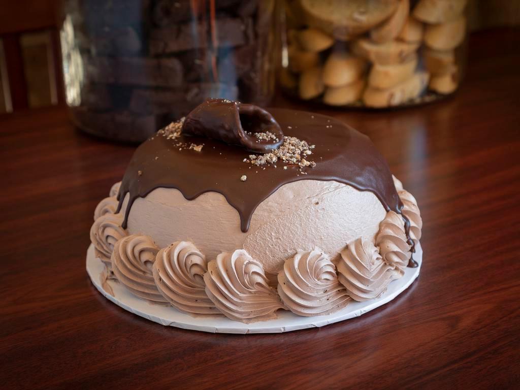 Chocolate Cannoli Cake · Chocolate cake filled with our famous chocolate cannoli filling, covered in chocolate Italian cream and dark chocolate ganache with a cannoli on top.