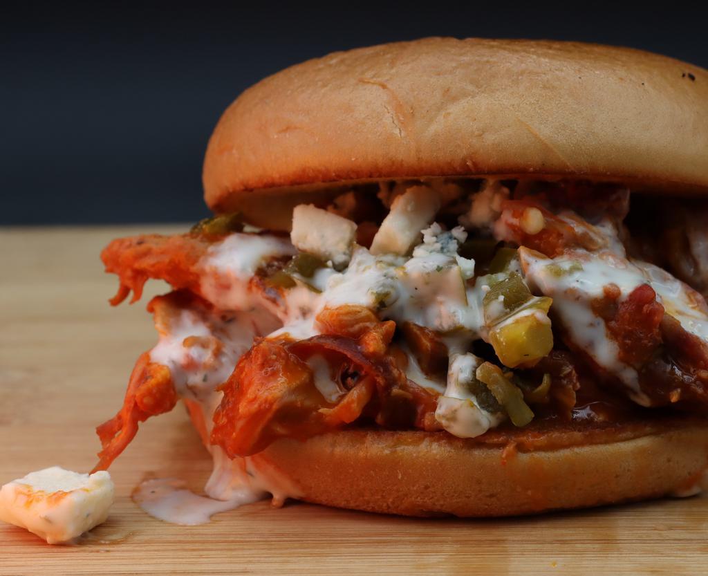 Buffalo Butt Sandwich · Shredded smoked pork tossed in Buffalo sauce topped with jalapenos and blue cheese rumbles drizzled with ranch dressing.