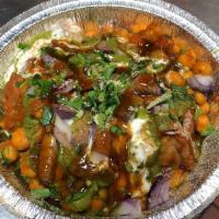 Samosa Chat · Samosa, chickpeas, spices, and yogurt drizzled with mint and tamarind chutney.