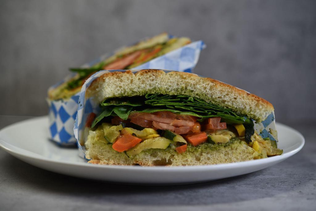 Roasted Veggie Sandwich · Roasted zucchini, summer squash mix with spinach, red onions, tomatoes with pesto sauce on focaccia bread.