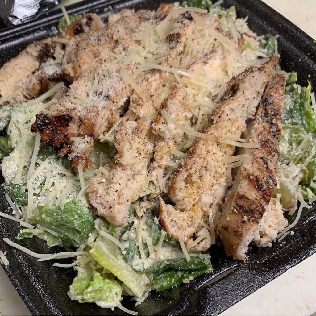 Chicken Caesar Salad · Crisp romaine topped with chicken, croutons, and grated Parmesan cheese. Served with Caesar dressing and a garlic breadstick.