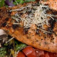 Grilled Salmon Salad · Sliced salmon marinated in a sauce then grilled. Served on crisp spring mix with sliced toma...
