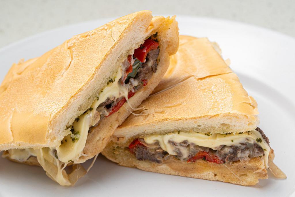 Cuban Philly Sandwich · Thin slices of Skirt Steak, grilled onions ＆ peppers, melted Swiss cheese topped with Chimichurri Sauce on toasted Cuban bread