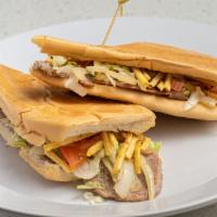 Pan con Bistec · Thin-cut Palomilla steak topped with grilled onions, lettuce, tomatoes ＆ potato sticks on to...