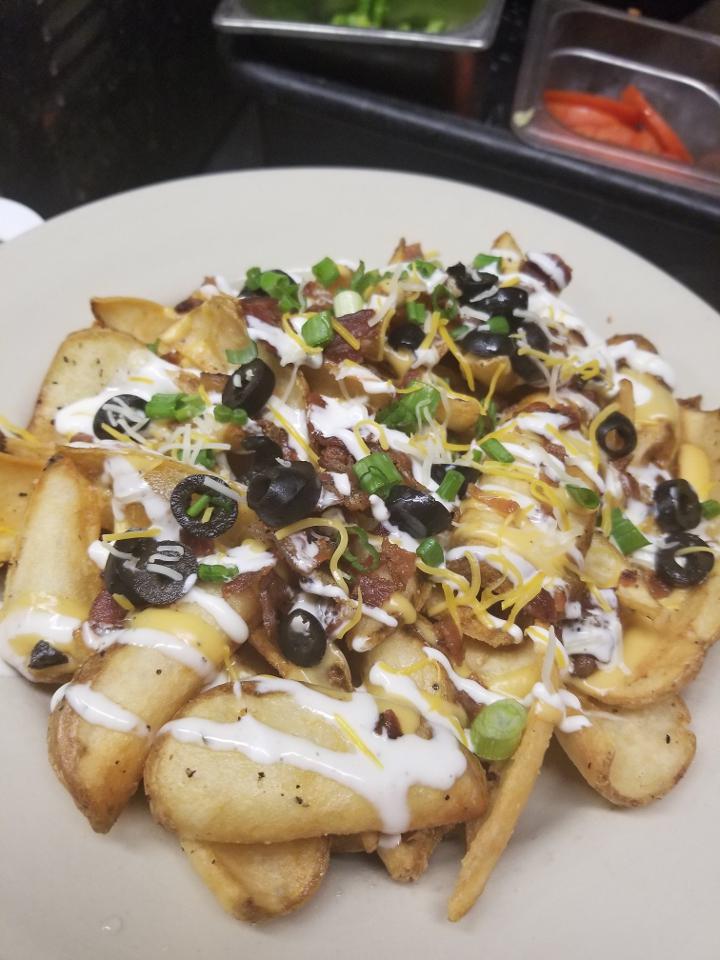 Loaded Taters · Potato scoops fried crispy, loaded with melty craft beer cheese, double smoked bacon, sour cream, ripe olives, and green onion drizzled with ranch dressing. dressings on the side to go