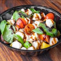 Caprese Salad · Pebbles of fresh mozzarella, tomatoes, and sweet basil, seasoned with salt and olive oil