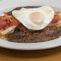 Bistec a Caballo · Grilled steak with onions, tomatoes, fried egg with rice, beans, salad, and sweet plantains.