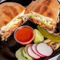 torta · Telera bread filled with cheese, pinto beans, meat, tomato, red onions, avocado, lettuce, ma...