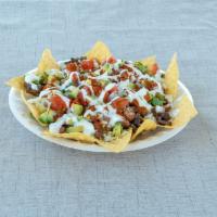 Nachos · Corn tortilla chips topped with meat, pinto beans, cheese, red onions, cilantro, tomato, avo...
