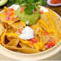 Nachos · Crispy chips, guacamole, nacho cheese, pico de gallo, sour cream, and cilantro aioli,