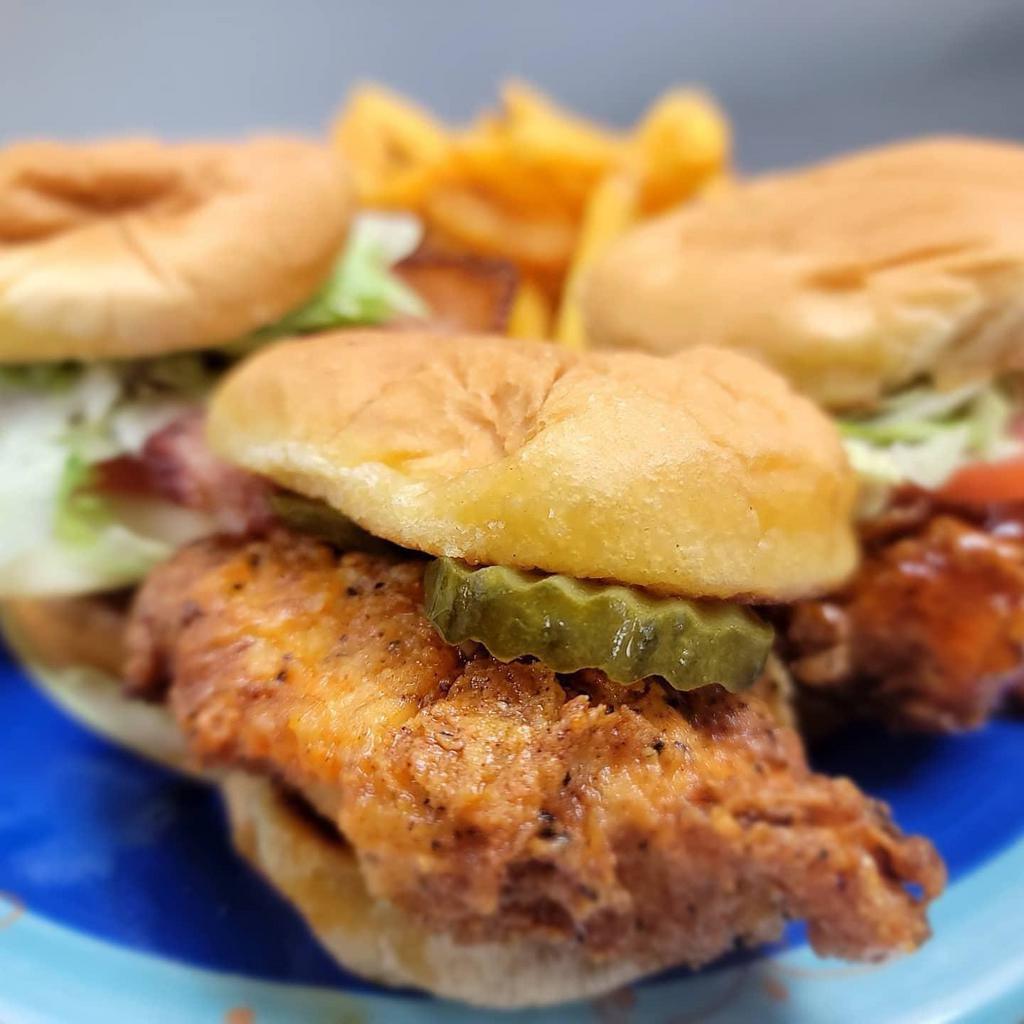 Chicken Slider Trio · 3 chicken sandwich sliders with a side of crispy fries. One original with bacon, lettuce, tomato, pickle, and cheese, one Nashville hot with sauce and pickle, and one sweet chili with lettuce and tomato.