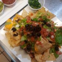 Nachos  · Pico de gallo, lettuce, bell peppers, black olives, melted cheese, and cheese sauce on a bed...