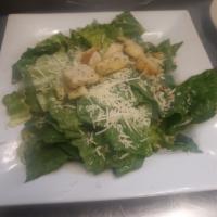 Caesar Salad  · Romaine lettuce tossed in Caesar dressing and topped with Parmesan cheese and croutons.