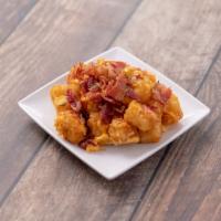 House Tater Tots · Tater tots with shredded mix cheese and pieces of bacon bits on top, drizzled with our house...