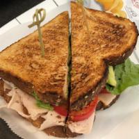 Turkey Club Sandwich · Sliced turkey, bacon, tomato & lettuce with a bag of chips