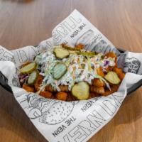 Nashville Hot Chicken Fries · Nashville chicken tenders, seasoned crinkle fries, tangy slaw, honey hot sauce, & pickles.