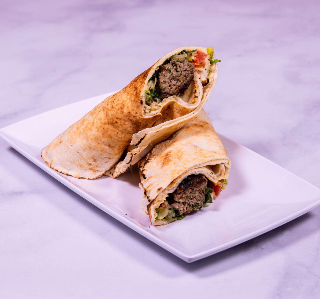 Lula Kabab Sandwich · Freshly ground lula kabab wrapped in pita bread with lettuce, tomato and tahini sauce.