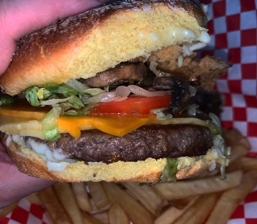 Badass Burger · Potato bun, Impossible 2.0 burger patty, vegan cheddar cheese, badass sauce, lettuce, tomato, and onions. Vegan. 