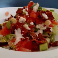 The Wedge Salad · Iceberg lettuce with creamy blue cheese dressing, bacon, tomatoes and green onions.