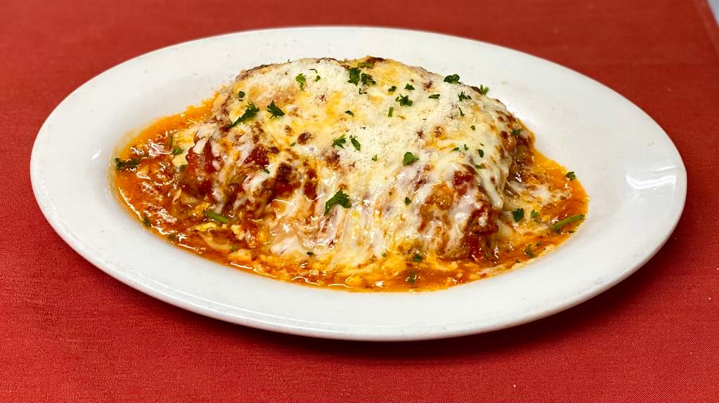 Lasagna Rustica · Homemade pasta stuffed with homemade pork and beef sauce, hardboiled eggs, ham, mozzarella & parmigiano cheese in a red sauce