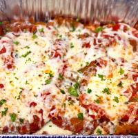 Eggplant Parmigiana Family Style · Hand-breaded eggplant fried and topped with mozzarella cheese and our homemade red sauce, se...