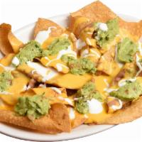 Nachos Supremos · Crispy tortillas chips smothered with melted nacho cheese. Served with refried beans, guacam...