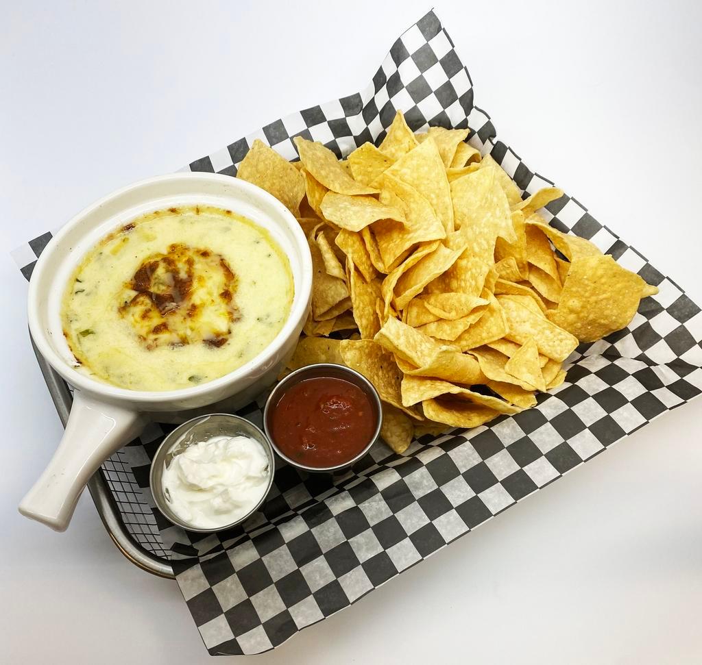 Spinach Artichoke Dip · Creamy mixture of spinach, tender artichokes & parmesan, served with tortilla chips, smoky salsa & sour cream