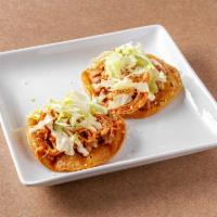 Tostada de Tinga · 1 fried tortilla topped with beans, shredded chipotle chicken, cheese crema and lettuce.