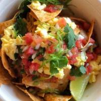 CHILAQUILES · slow cooked cage-free eggs, local tortilla chips, roasted peppers, onions, pico de gallo, ci...
