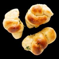 Garlic Knots x3 · Fresh baked knots topped with garlic and parsley. Comes with Marinara.