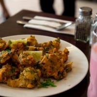 Fresh Vegetable Pakoras · Spinach, onions and potatoes fritters dipped in chickpea flour batter and fried.