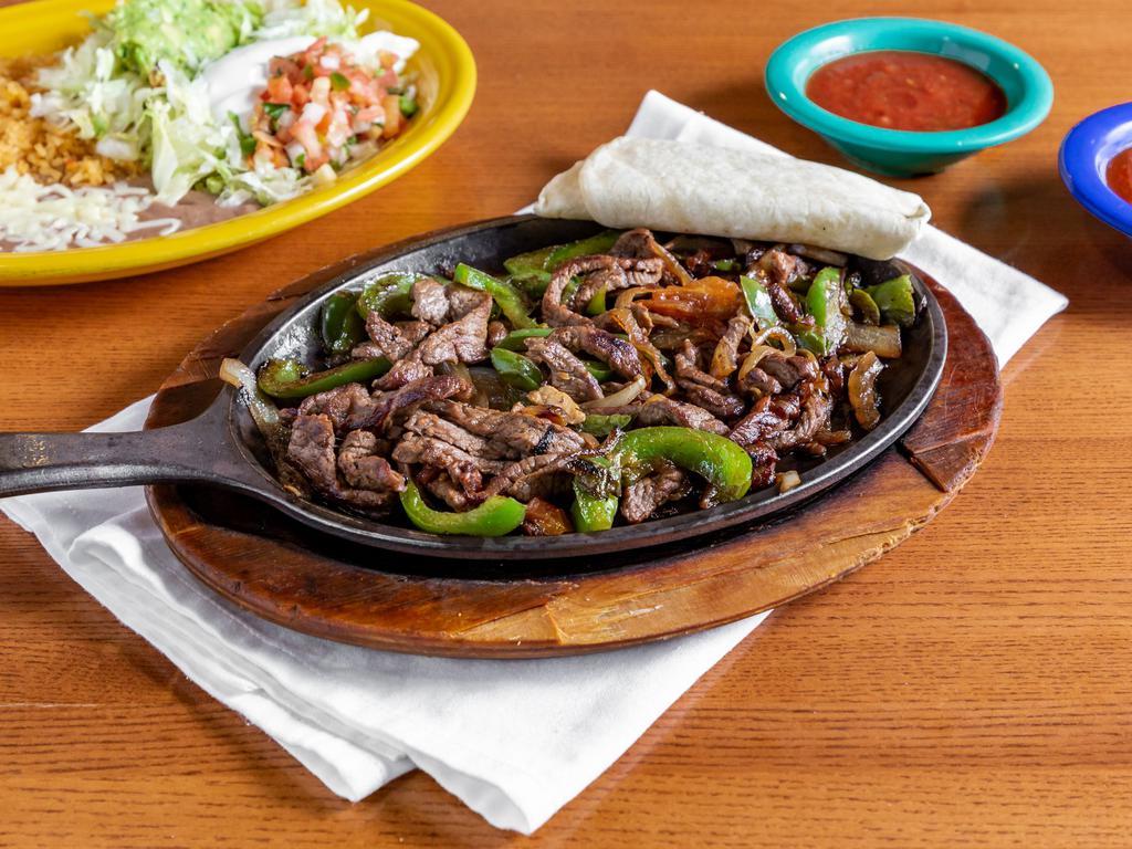 Steak Fajita · Steak grilled with bell peppers, tomatoes, and onions. Served with rice, beans, pico, guacamole, sour cream, lettuce, and tortillas.