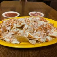 Chicken Nachos · A bed of crispy tortilla chips, smother with cheese dip, topped with chicken (chicken is alr...
