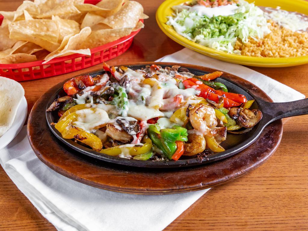 Pollo Fundido · Grilled chicken and shrimp cooked with mushrooms and peppers. Topped with cheese and served with rice, beans, lettuce, guacamole, sour cream, pico de gallo, and a side of tortillas.