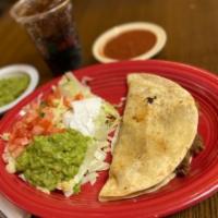 Quesadilla Mexicana · A flour tortilla grilled and stuffed with cheese, beef, and refried beans. Served with lettu...