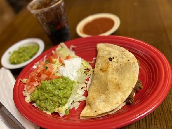 Quesadilla Mexicana · A flour tortilla grilled and stuffed with cheese, beef, and refried beans. Served with lettuce, tomato, guacamole, and sour cream.
