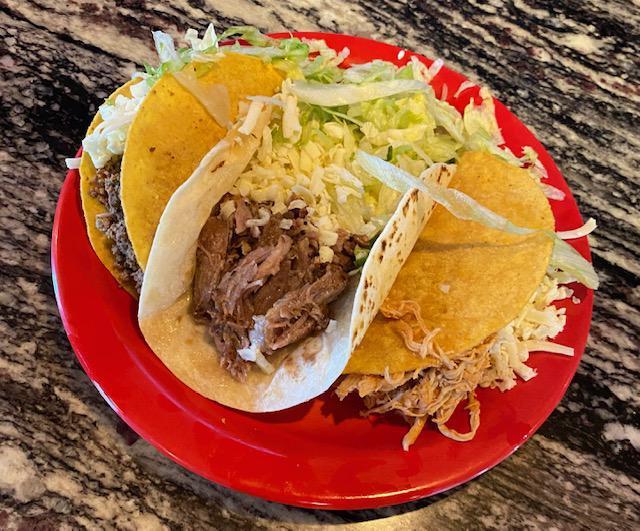 Taco · A corn hard shell or soft flour shell filled with ground beef, shredded chicken, or pork topped with White shredded cheese and lettuce.