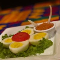 Spicy African Deviled Eggs · Served with hot sauce.