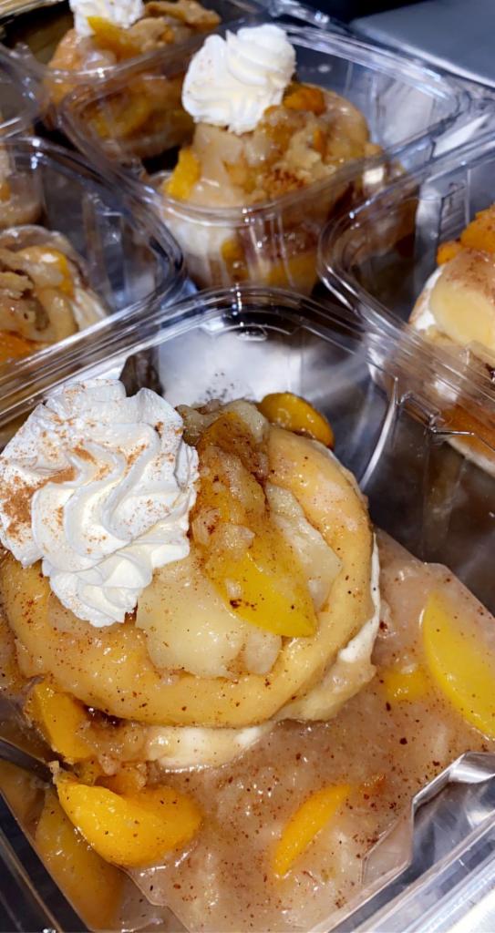 Stuffed Cheesecake Donuts · Delicious fresh made donuts stuffed with creamy cheesecake and topped with your choice of peach cobbler or strawberry shortcake 