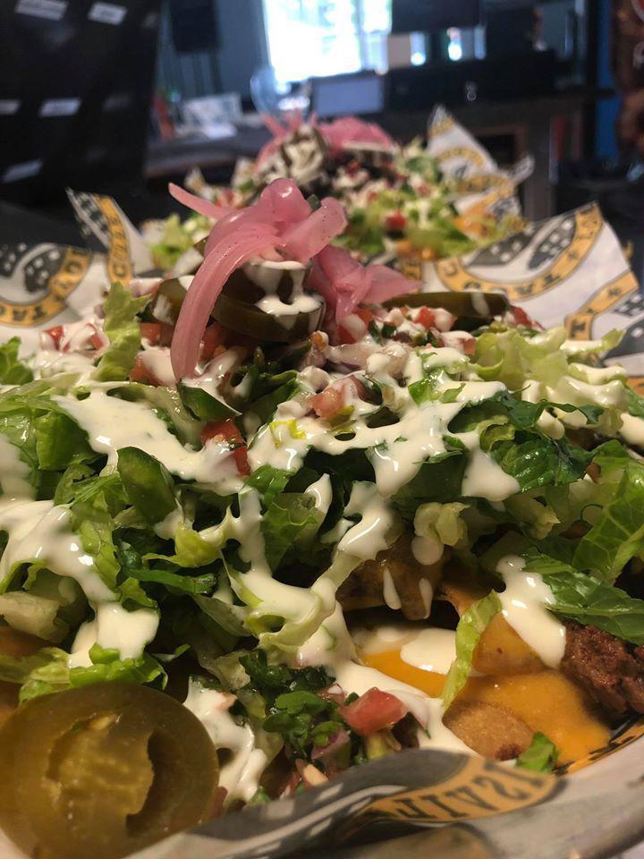 NACHOS · TORTILLA CHIPS WITH CHICKEN OR STEAK, WHITE CHEESE SAUCE,PINTO BEANS,YELLOW NACHO CHEESE,LETTUCE, PICO DE GALLO, JALAPENOS,PICKLED ONIONS AND CREMA MEXICANA