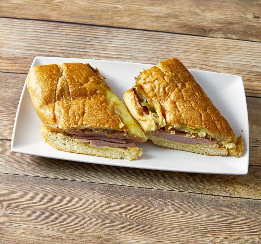 Sandwich Cubano · Smoked ham, roast pork, Swiss cheese, pickles, and mustard.