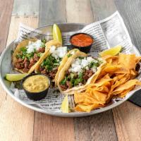 Original Steak Street Tacos · Marinated steak tacos, topped with cilantro and onion, served with tortilla chips and a home...