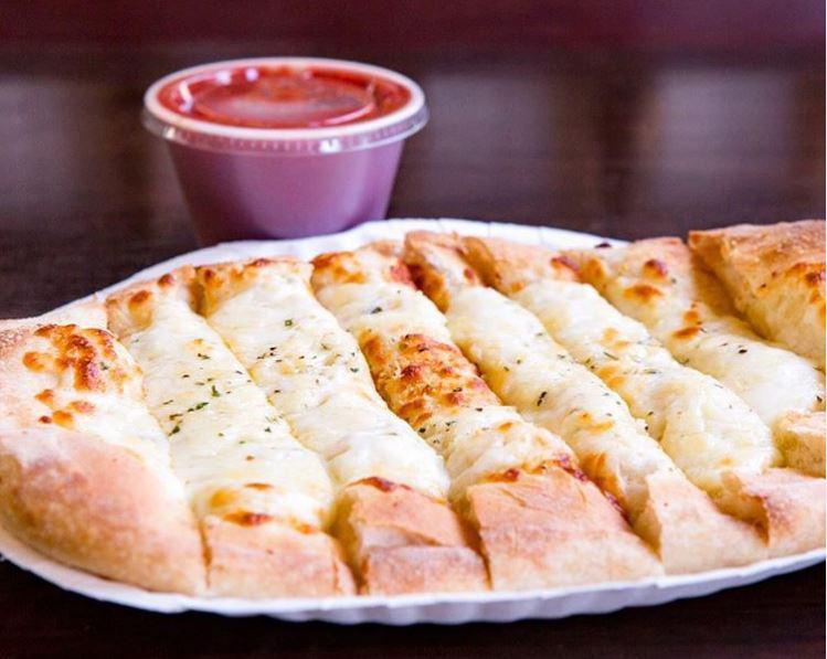 Cheesy Breadstix · Pizza dough topped with cheese and garlic seasoning with a side of pizza sauce.